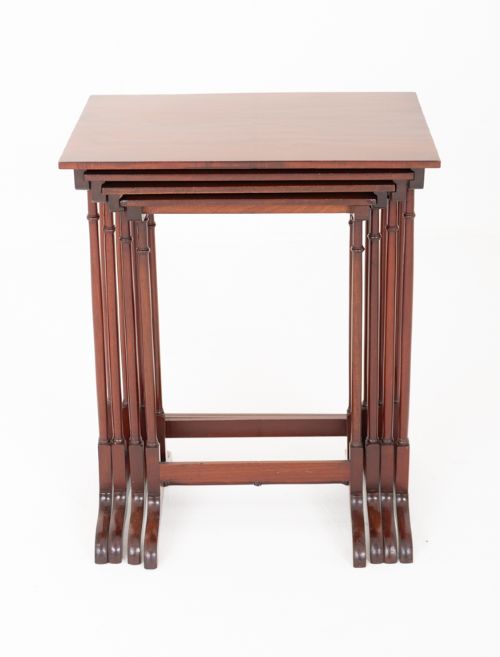A set of four graduating mahogany nesting tables featuring slender turned legs and splayed trestle feet. View II