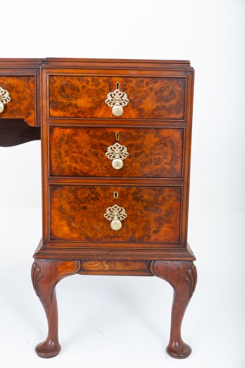 A Queen Anne style burr walnut kneehole desk featuring an inset dark leather writing top, brass drop handles, and cabriole legs. View IX