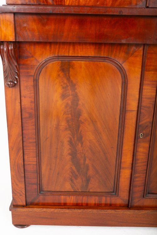 A two-piece Victorian mahogany library bookcase featuring arched glazed doors on the upper section and flame mahogany cupboard doors on the lower base. View II