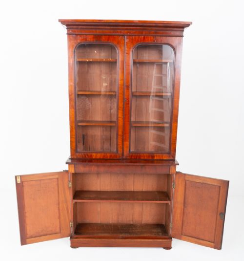 A two-piece Victorian mahogany library bookcase featuring arched glazed doors on the upper section and flame mahogany cupboard doors on the lower base. View V