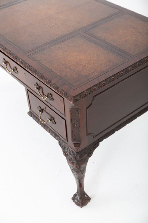 A dark mahogany Chippendale style writing desk featuring an inset leather top, carved cabriole legs with ball-and-claw feet, and brass drawer handles. View X