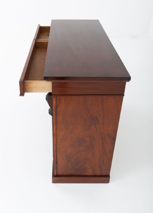 A nineteenth-century Victorian mahogany side cabinet featuring two flame mahogany veneered doors flanked by decorative carved corbels. View VIII