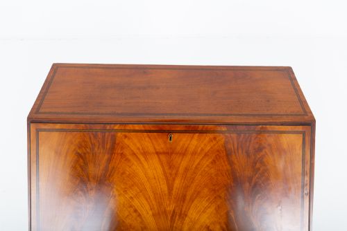 fig 2. An antique mahogany writing bureau featuring a sloped fall-front flap over four graduated drawers with ornate brass handles and bracket feet.