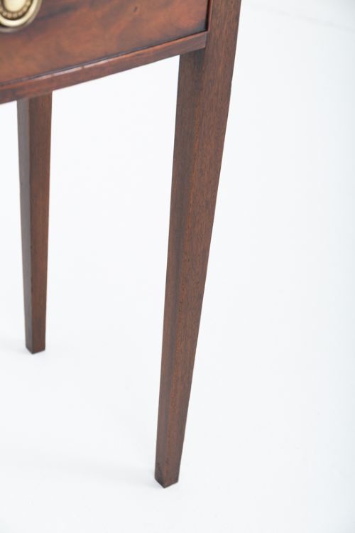 fig 1. A Regency mahogany bow-front side table featuring two drawers with brass ring handles and slender square tapered legs.