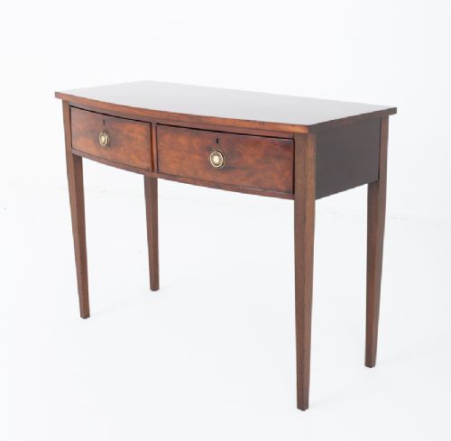 A Regency mahogany bow-front side table featuring two drawers with brass ring handles and slender square tapered legs. View III