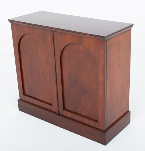 A Victorian mahogany side cabinet featuring two recessed arched panel doors and a solid plinth base. View III