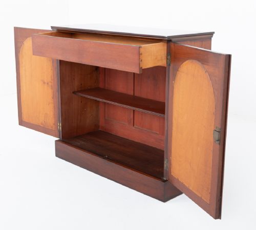 A Victorian mahogany side cabinet featuring two recessed arched panel doors and a solid plinth base. View VIII
