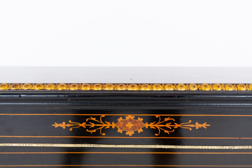 An ebonised Victorian pier cabinet with gilt brass mounts, detailed wood inlay, a single glazed door, and red-lined interior shelves. View VII