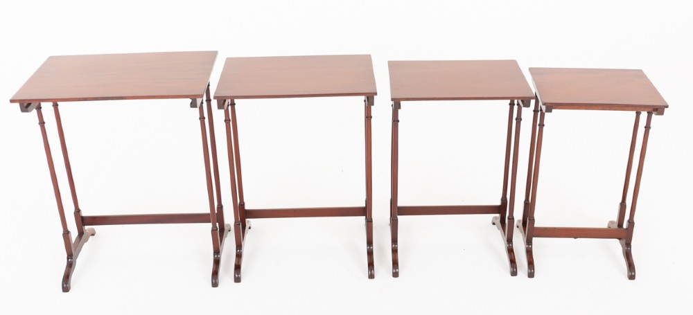 A set of four graduating mahogany nesting tables featuring slender turned legs and splayed trestle feet. View VI
