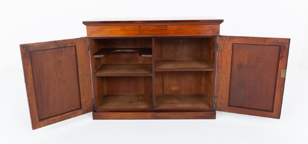 A nineteenth-century Victorian mahogany side cabinet featuring two flame mahogany veneered doors flanked by decorative carved corbels. View VI