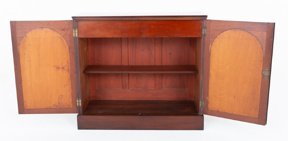 A Victorian mahogany side cabinet featuring two recessed arched panel doors and a solid plinth base. View V