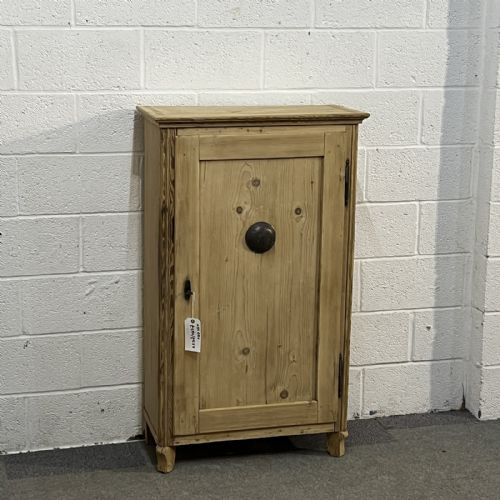 fig 1. An antique single door pine larder cupboard featuring a central circular metal vent and dark iron hinges.
