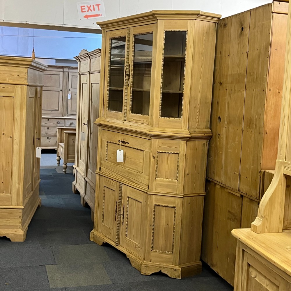 A large natural pine secretaire bookcase featuring glazed upper doors, a fold-down desk surface with internal drawers, and a lower two-door cupboard. View IV