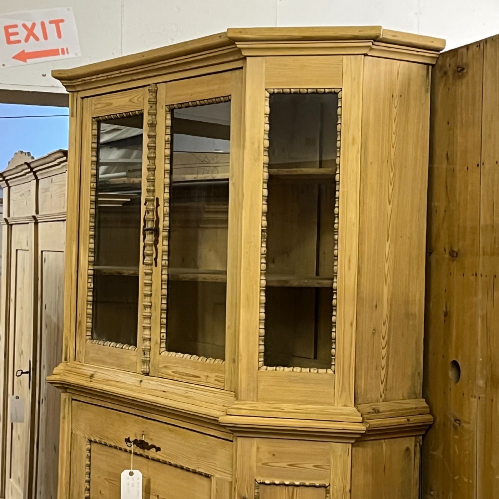 A large natural pine secretaire bookcase featuring glazed upper doors, a fold-down desk surface with internal drawers, and a lower two-door cupboard. View VIII