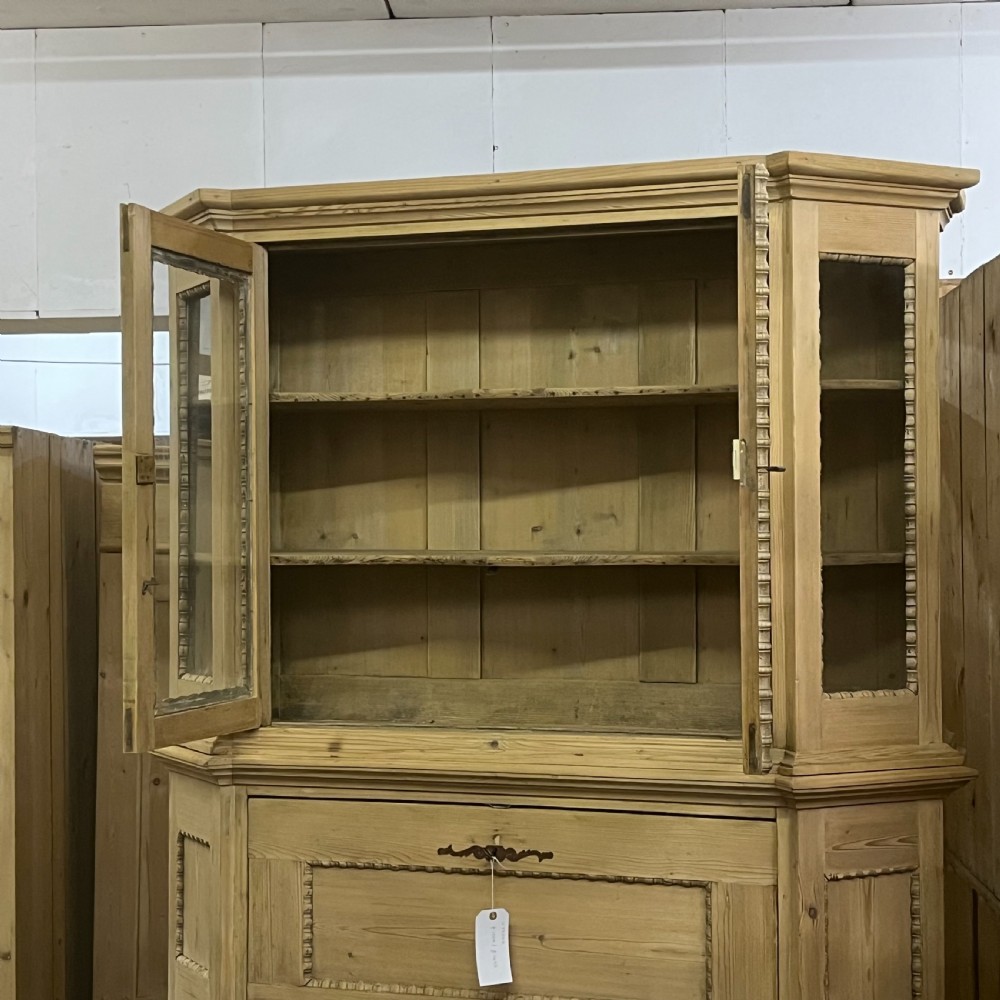A large natural pine secretaire bookcase featuring glazed upper doors, a fold-down desk surface with internal drawers, and a lower two-door cupboard. View IX