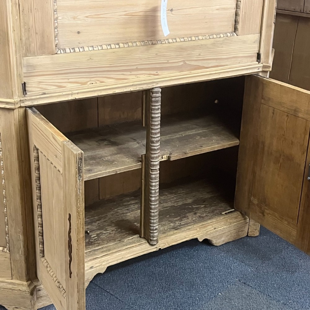 A large natural pine secretaire bookcase featuring glazed upper doors, a fold-down desk surface with internal drawers, and a lower two-door cupboard. View XI