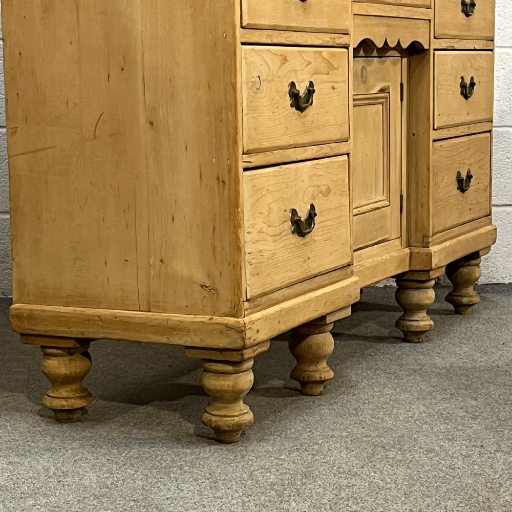 A Victorian stripped pine chiffonier sideboard featuring a decorative raised gallery back with a carved crest, small drawers, a central cupboard, and turned bun feet. View XI