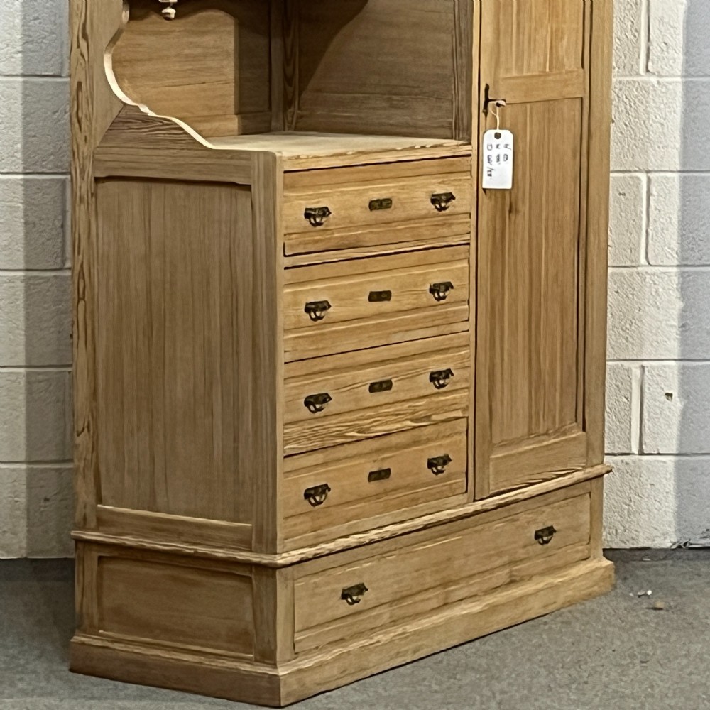A tall antique stripped pine combination cupboard unit featuring a single long door, upper cabinet, open alcove, side drawers, and a base drawer. View IX