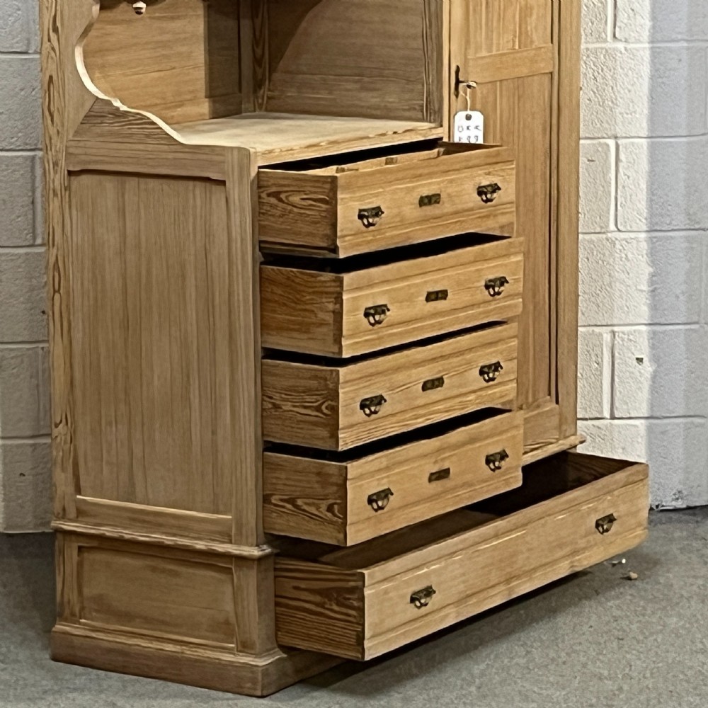 A tall antique stripped pine combination cupboard unit featuring a single long door, upper cabinet, open alcove, side drawers, and a base drawer. View X