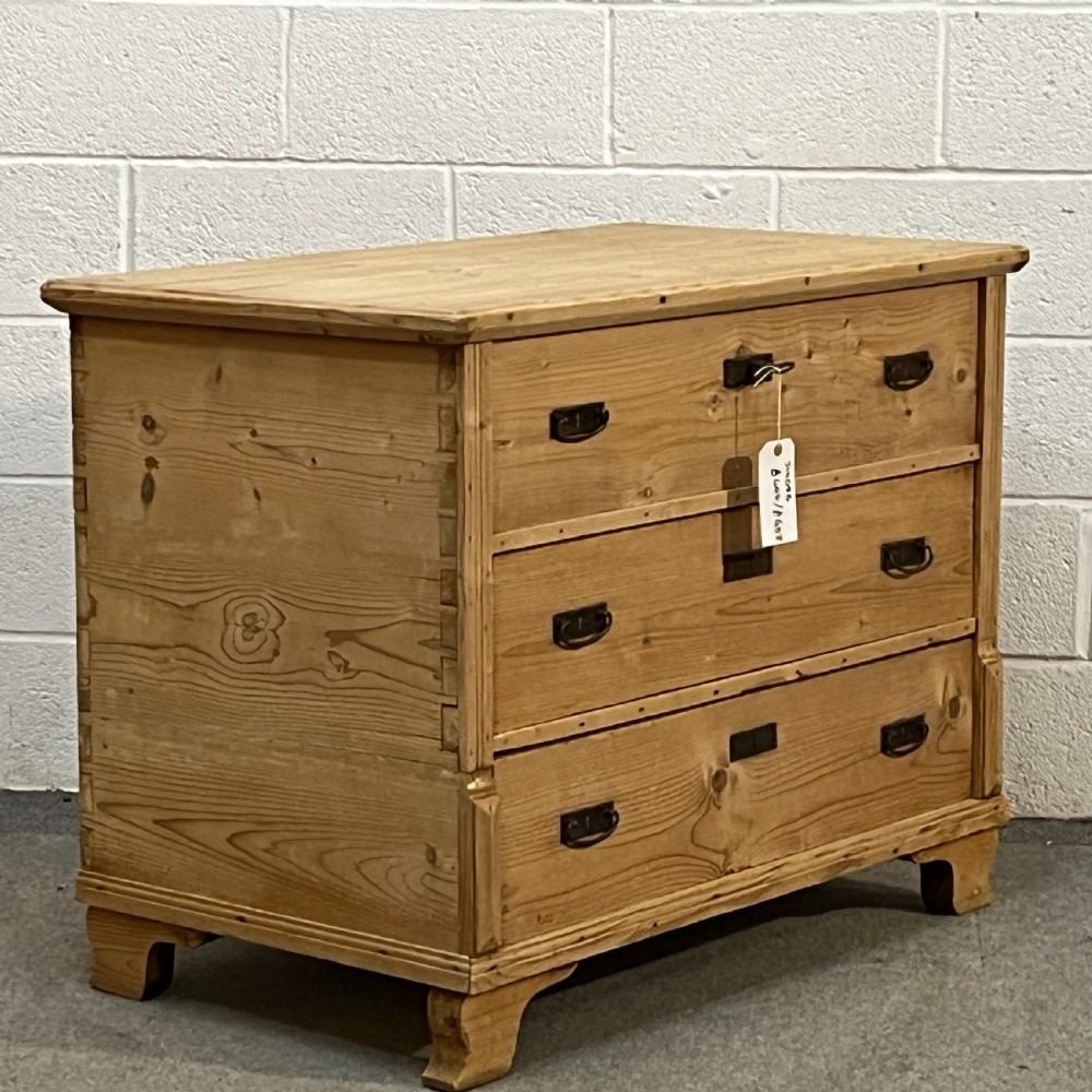 A large natural pine mule chest featuring an open hinged lid above lower drawers with dark metal pull handles and bracket feet. View III