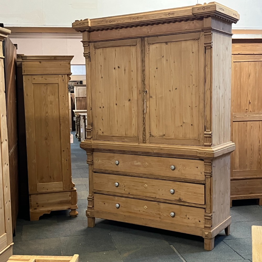 A tall nineteenth-century Dutch pine linen press featuring a twin-panelled upper cupboard set over a lower base of three wide drawers with turned knobs. View III