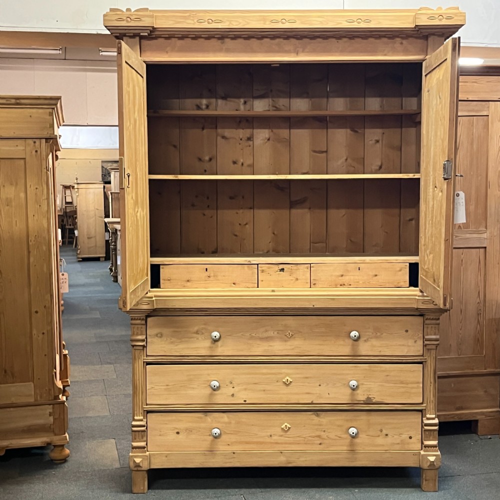 A tall nineteenth-century Dutch pine linen press featuring a twin-panelled upper cupboard set over a lower base of three wide drawers with turned knobs. View VI