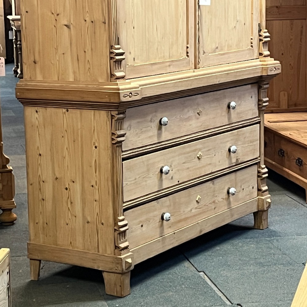 A tall nineteenth-century Dutch pine linen press featuring a twin-panelled upper cupboard set over a lower base of three wide drawers with turned knobs. View VIII