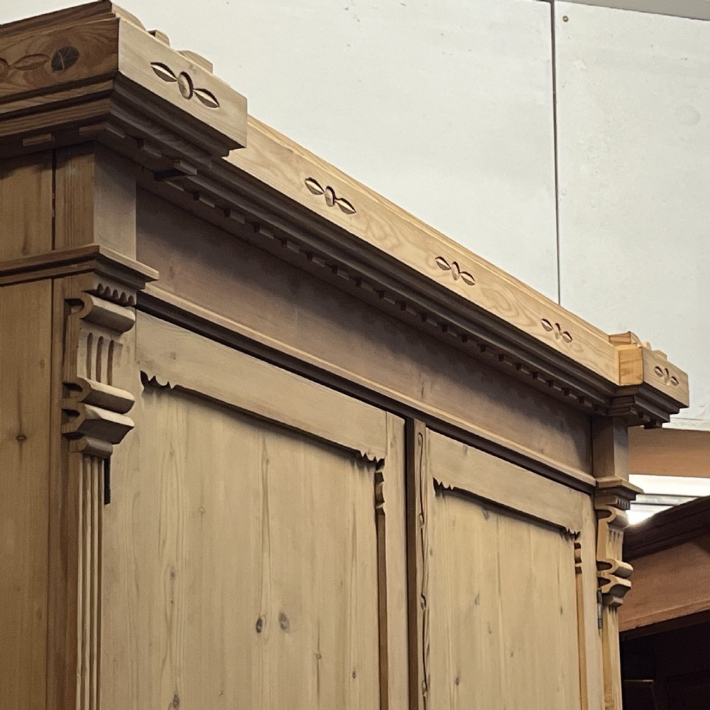 A tall nineteenth-century Dutch pine linen press featuring a twin-panelled upper cupboard set over a lower base of three wide drawers with turned knobs. View IX