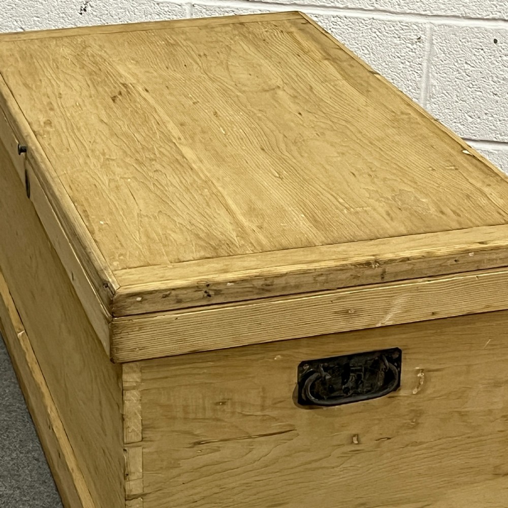 A large rectangular natural pine blanket chest featuring dovetailed joints, a hinged top lid, and a central keyhole escutcheon. View V