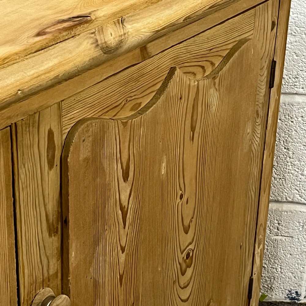 A small Edwardian pine chiffonier featuring three drawers on the left with turned wooden knob handles, a single panelled cupboard door on the right, and rounded bun feet. View V