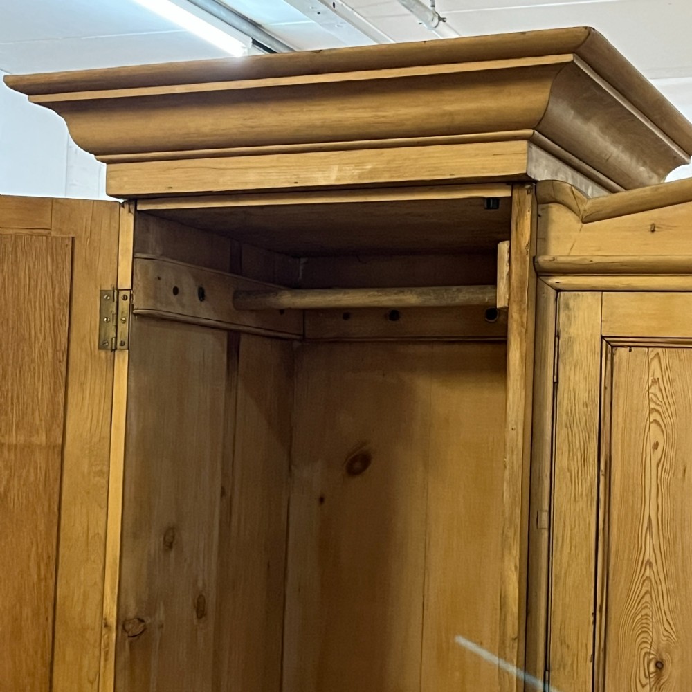 A large Victorian pine combination wardrobe featuring a central chest of drawers and upper cupboard, flanked by two full-length mirrored side doors with arched tops. View V