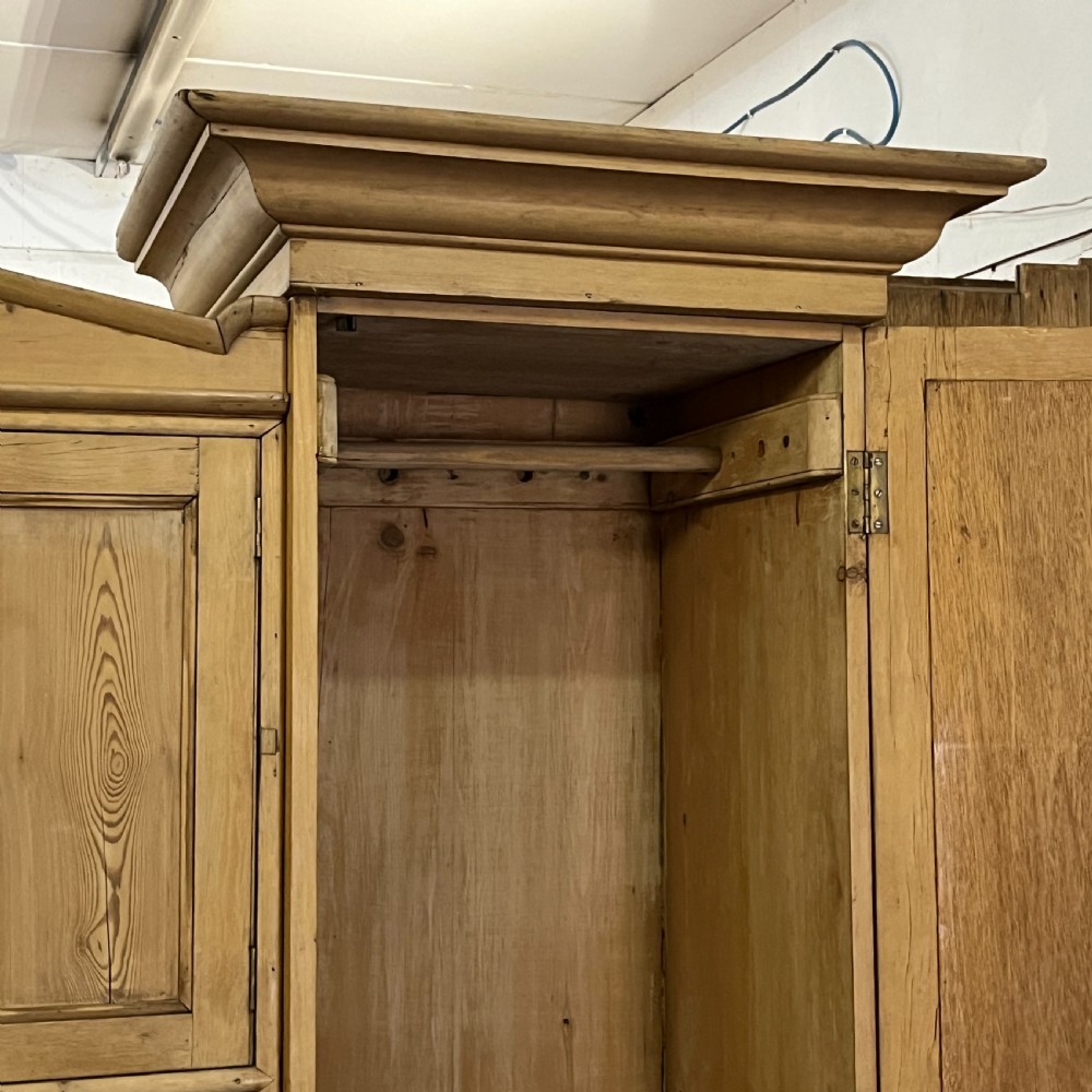 A large Victorian pine combination wardrobe featuring a central chest of drawers and upper cupboard, flanked by two full-length mirrored side doors with arched tops. View VI