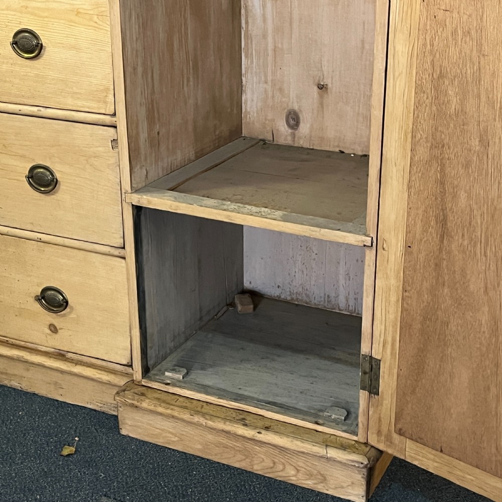A large Victorian pine combination wardrobe featuring a central chest of drawers and upper cupboard, flanked by two full-length mirrored side doors with arched tops. View X