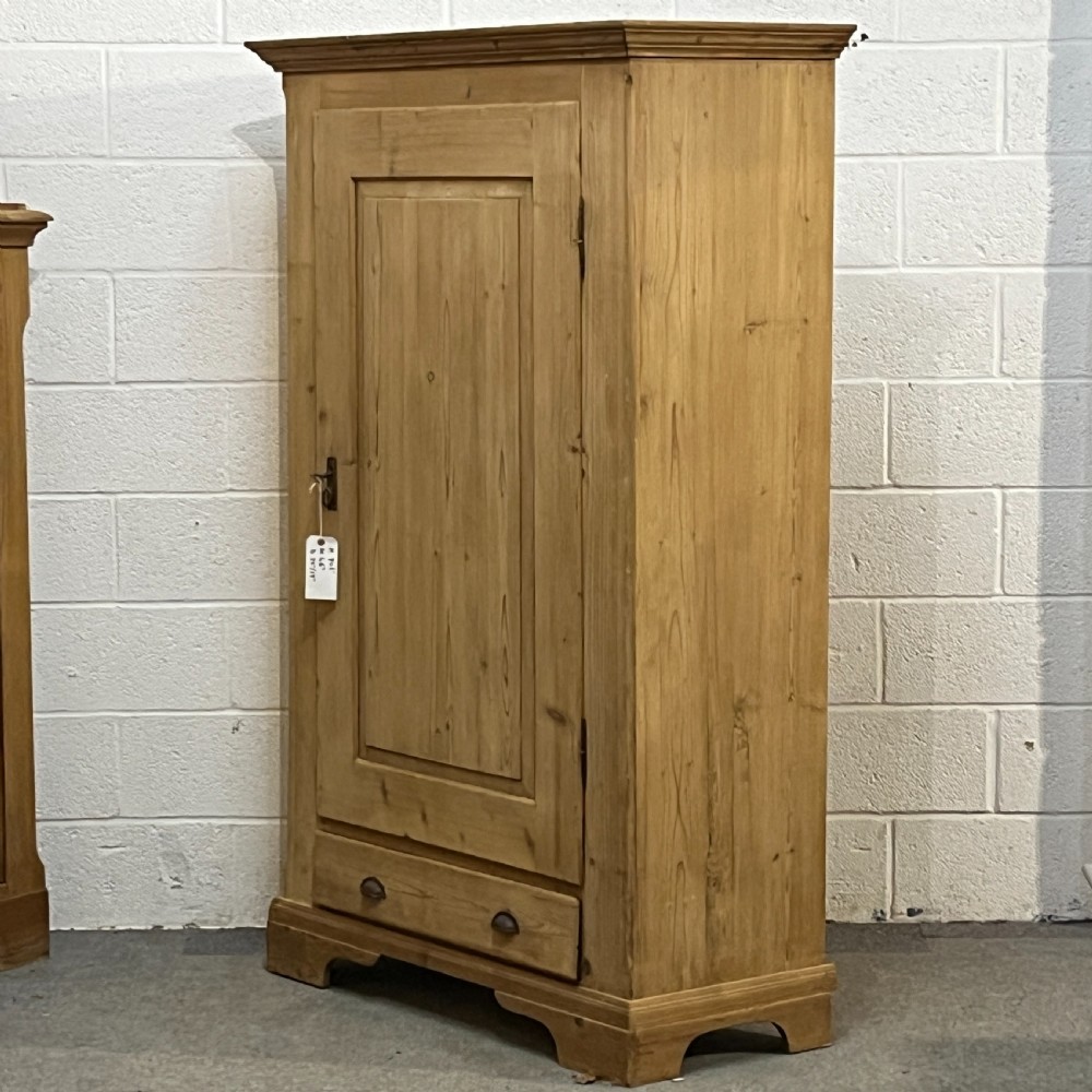 A single-door antique pine wardrobe featuring a central recessed panel, a bottom drawer with shell cup handles, and a moulded top cornice. View II