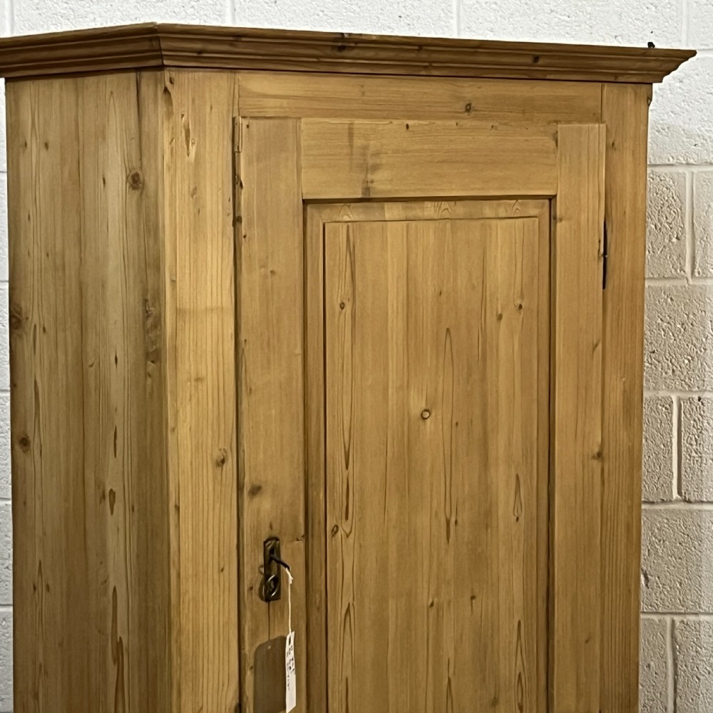 A single-door antique pine wardrobe featuring a central recessed panel, a bottom drawer with shell cup handles, and a moulded top cornice. View IV