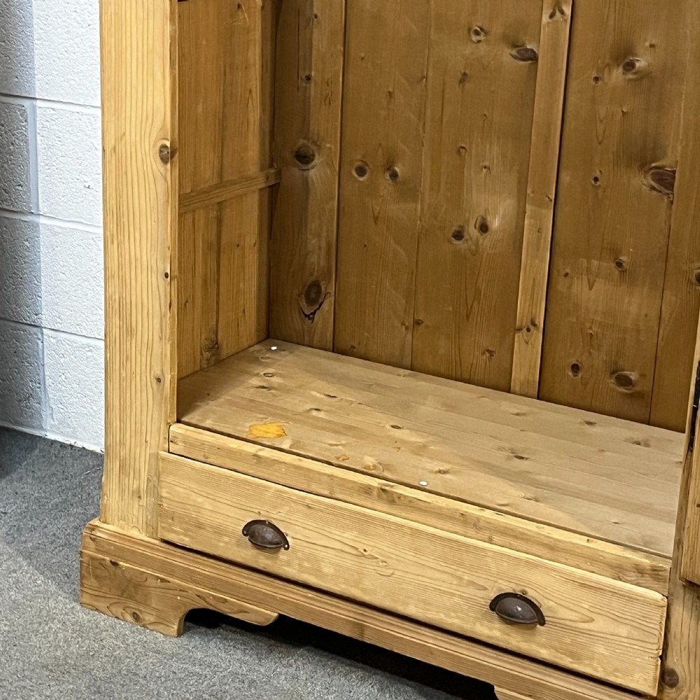 A single-door antique pine wardrobe featuring a central recessed panel, a bottom drawer with shell cup handles, and a moulded top cornice. View VIII