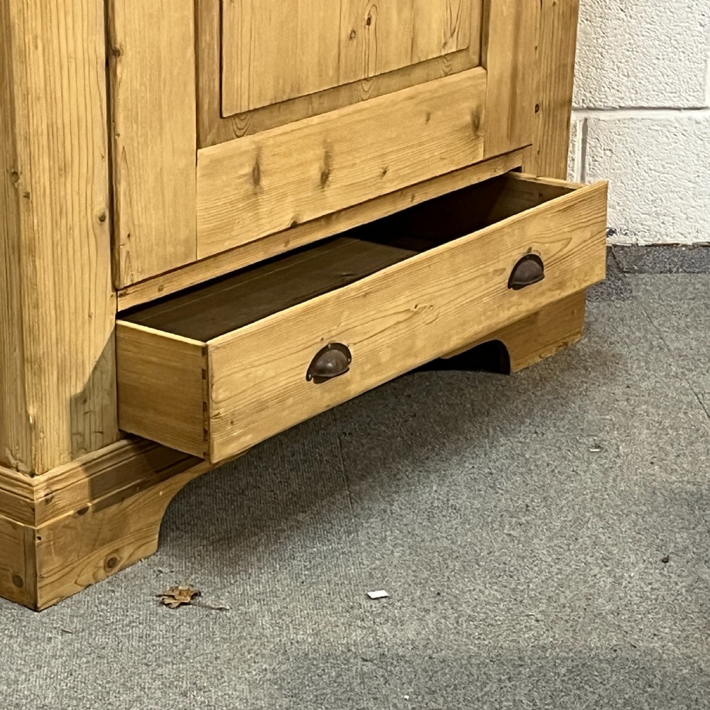 A single-door antique pine wardrobe featuring a central recessed panel, a bottom drawer with shell cup handles, and a moulded top cornice. View IX