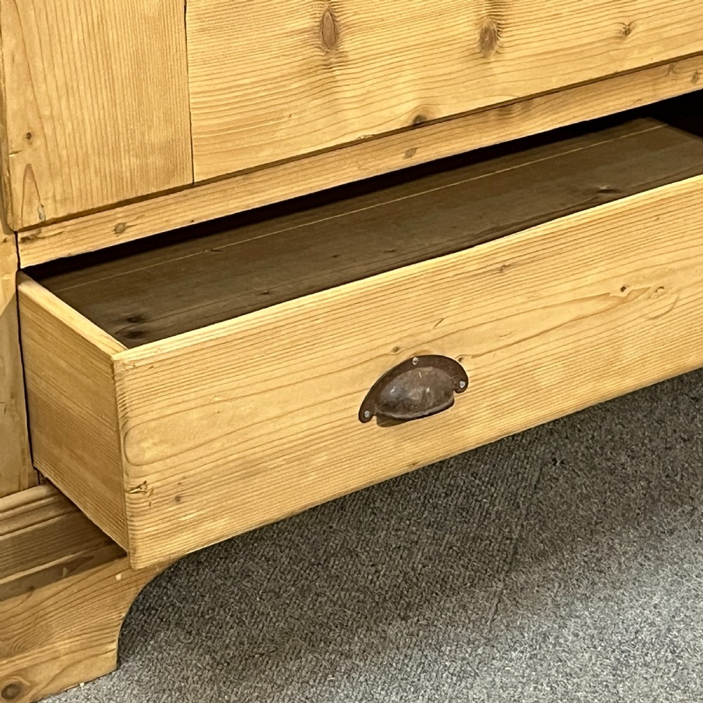 A single-door antique pine wardrobe featuring a central recessed panel, a bottom drawer with shell cup handles, and a moulded top cornice. View X