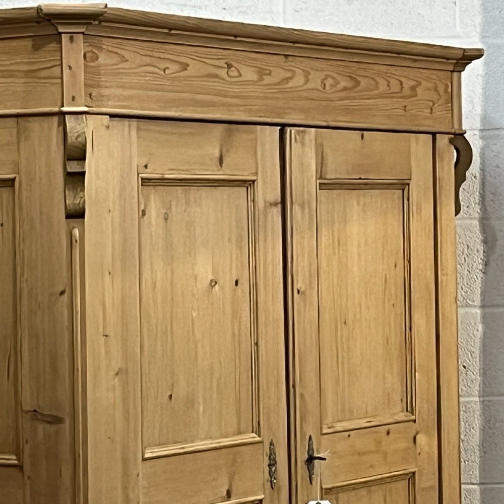 A large antique pine double wardrobe featuring panelled doors, two bottom drawers with turned handles, and a moulded top cornice. View VI
