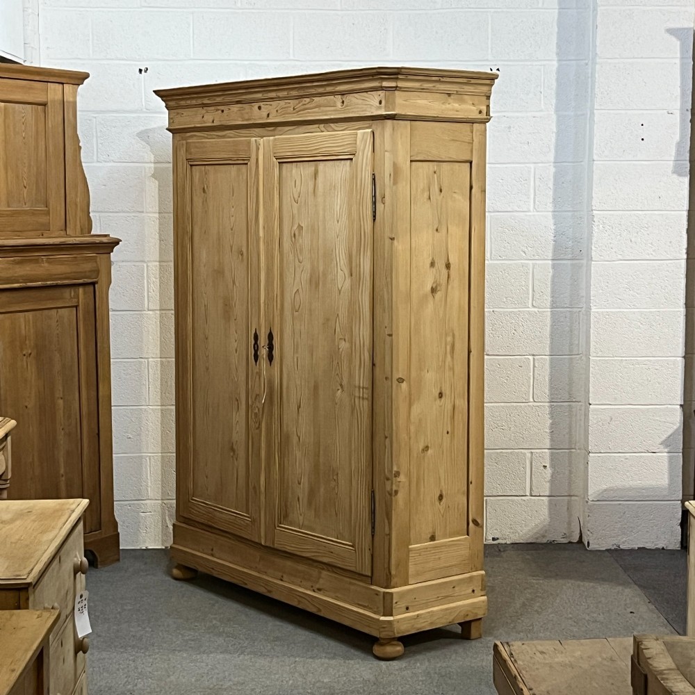 A large French pine double wardrobe featuring twin panelled doors, iron escutcheons, a moulded cornice, and rounded feet. View III