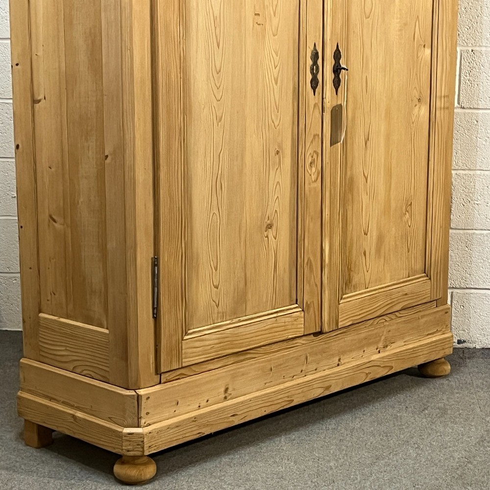 A large French pine double wardrobe featuring twin panelled doors, iron escutcheons, a moulded cornice, and rounded feet. View V