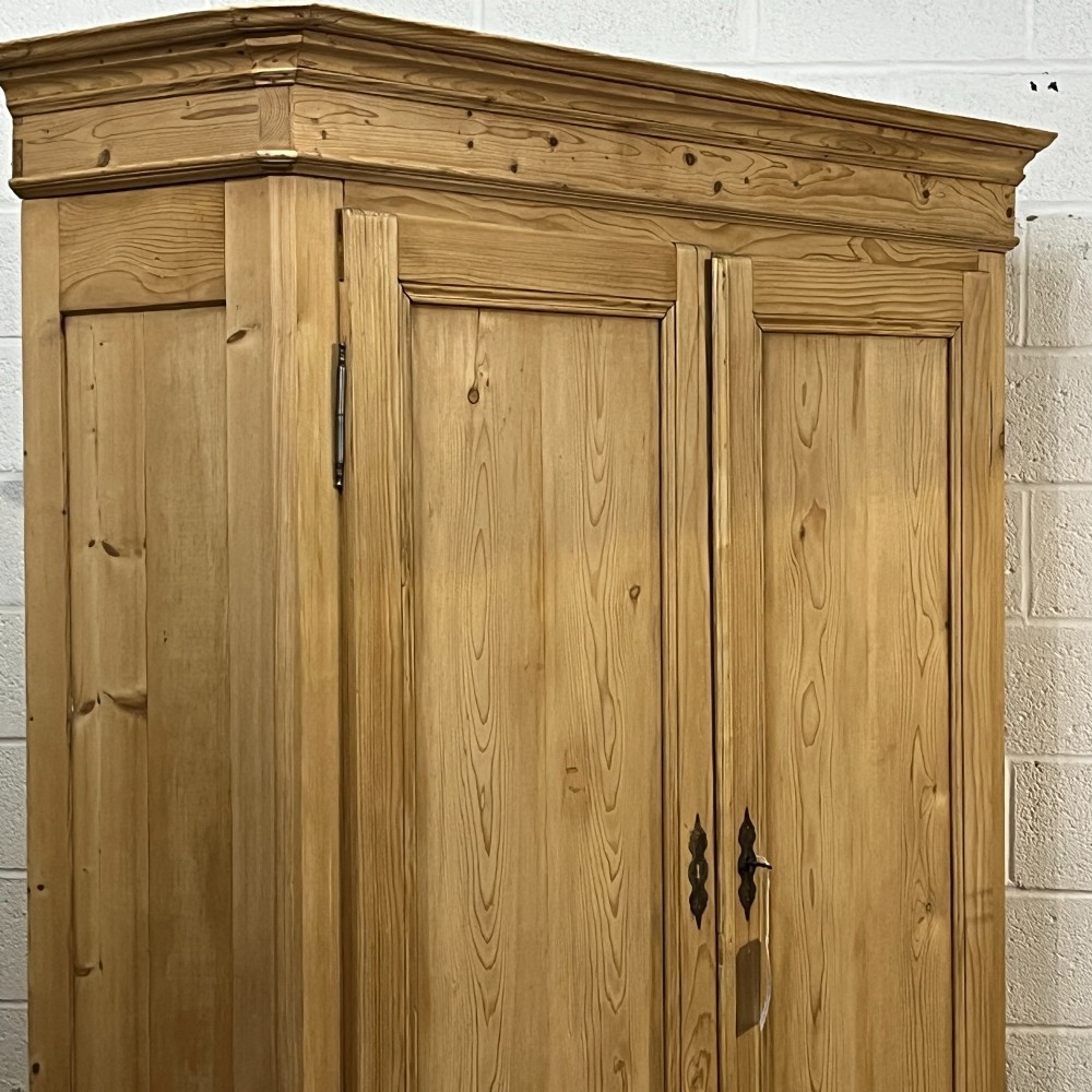 A large French pine double wardrobe featuring twin panelled doors, iron escutcheons, a moulded cornice, and rounded feet. View VI