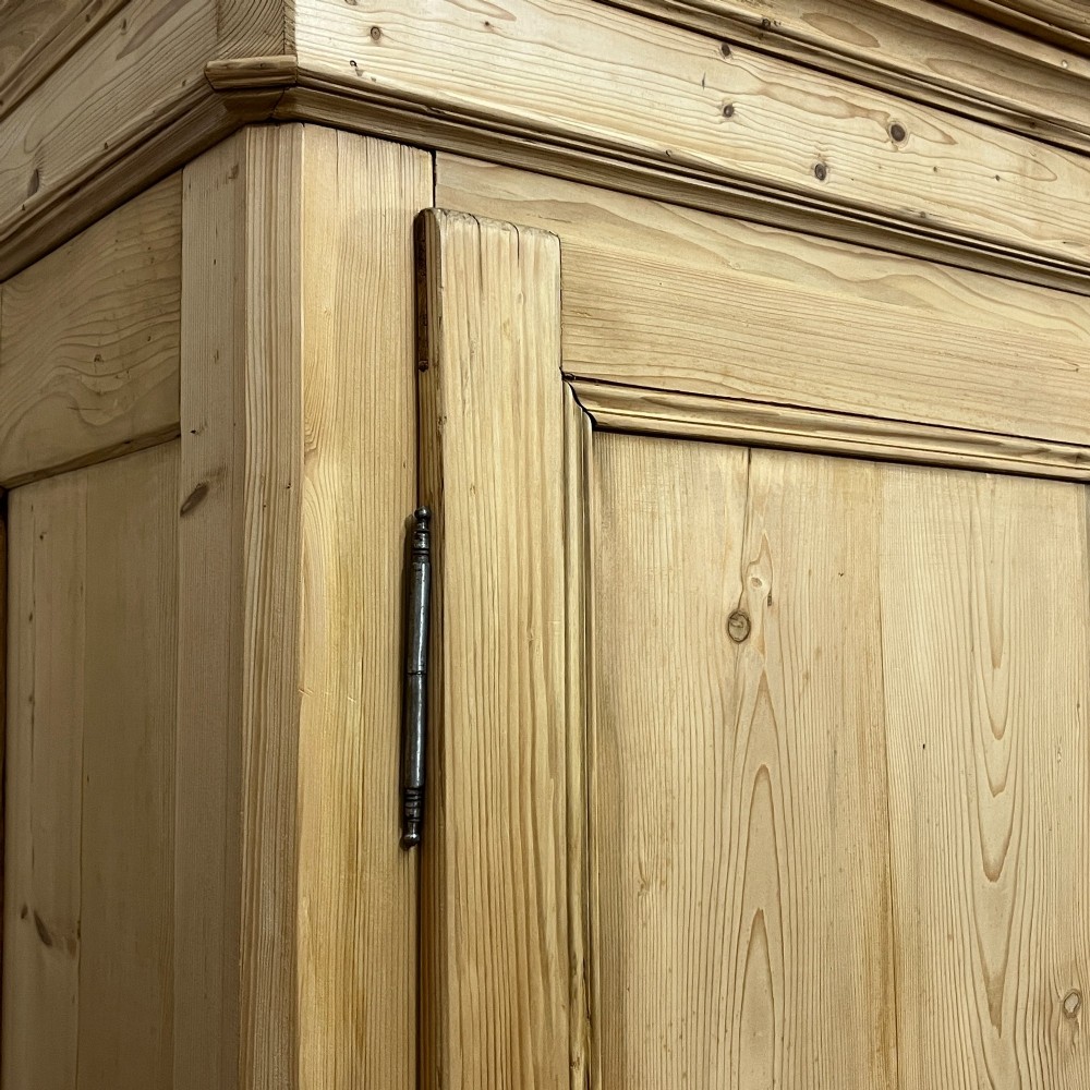 A large French pine double wardrobe featuring twin panelled doors, iron escutcheons, a moulded cornice, and rounded feet. View VII