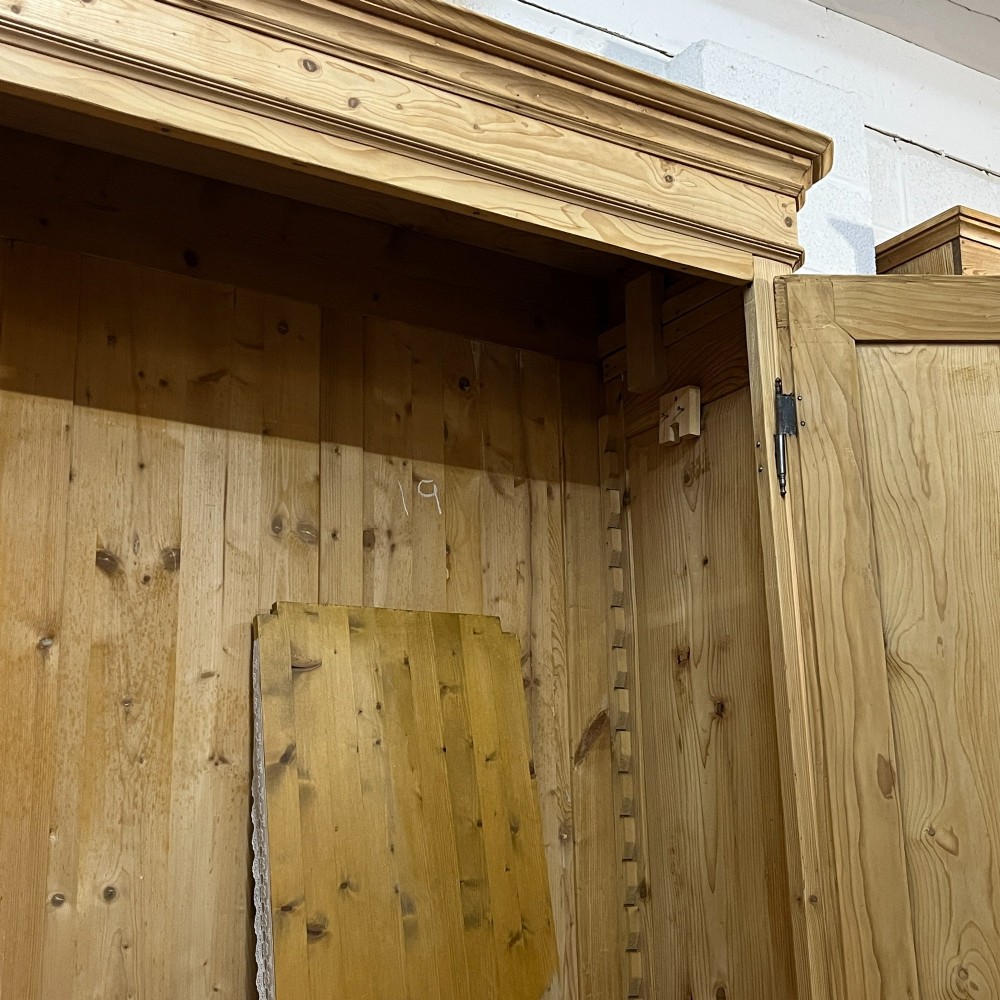 A large French pine double wardrobe featuring twin panelled doors, iron escutcheons, a moulded cornice, and rounded feet. View VIII