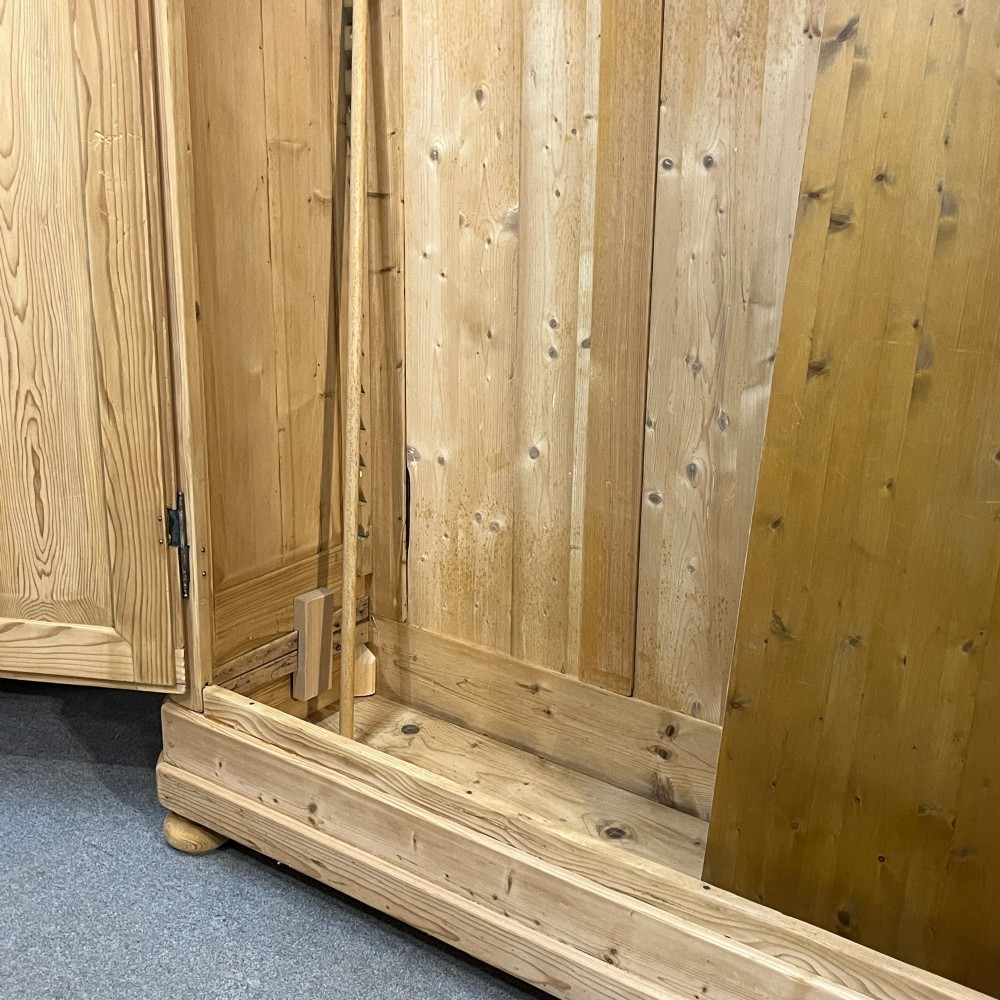 A large French pine double wardrobe featuring twin panelled doors, iron escutcheons, a moulded cornice, and rounded feet. View IX