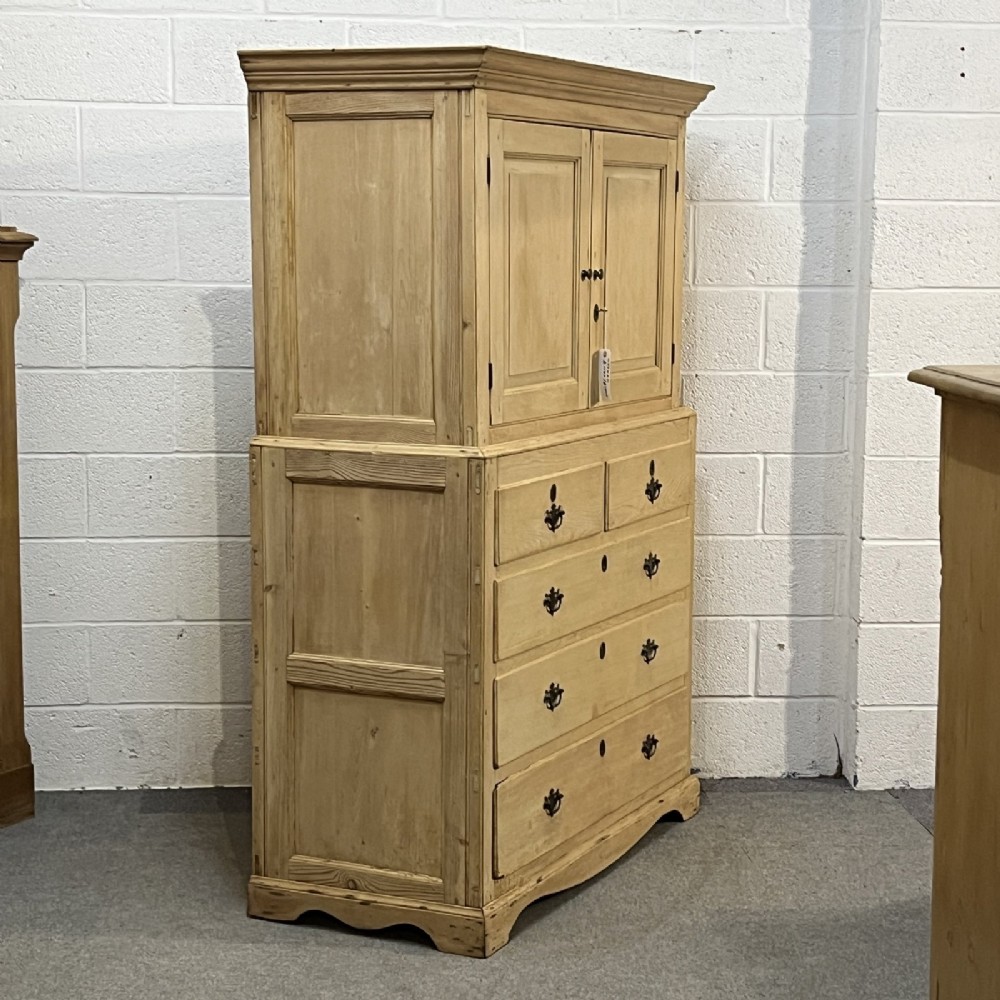 A nineteenth-century pale pine linen press featuring a double-door top cupboard set above two short and three long graduated drawers with brass handles. View III