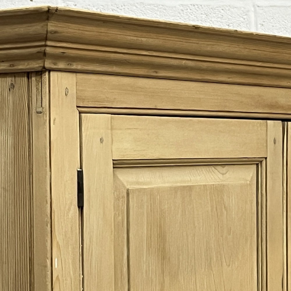 A nineteenth-century pale pine linen press featuring a double-door top cupboard set above two short and three long graduated drawers with brass handles. View X