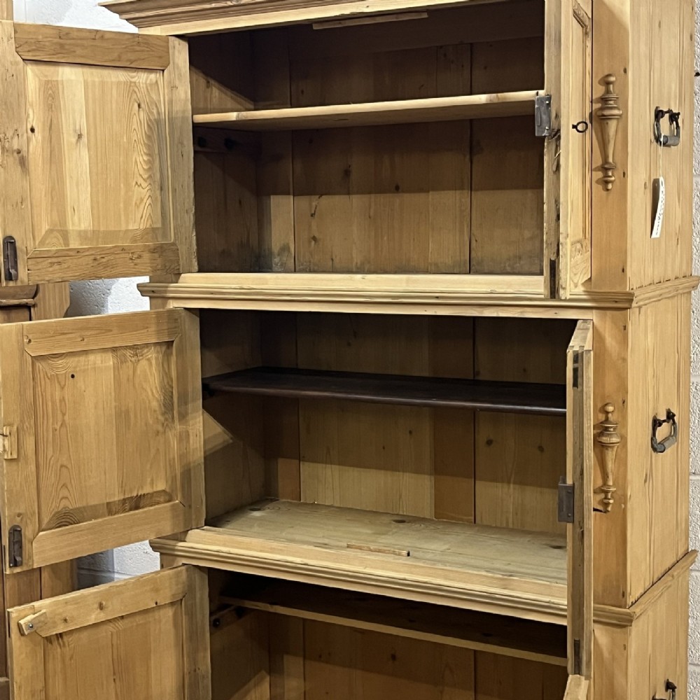 A three-section antique pine campaign cupboard featuring panelled doors, iron carrying handles on the sides, and rounded bun feet. View IV