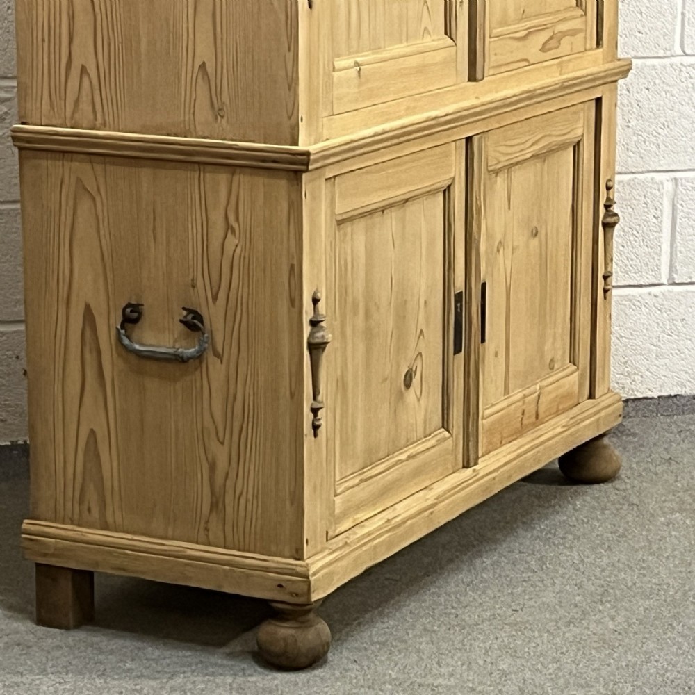 A three-section antique pine campaign cupboard featuring panelled doors, iron carrying handles on the sides, and rounded bun feet. View VII