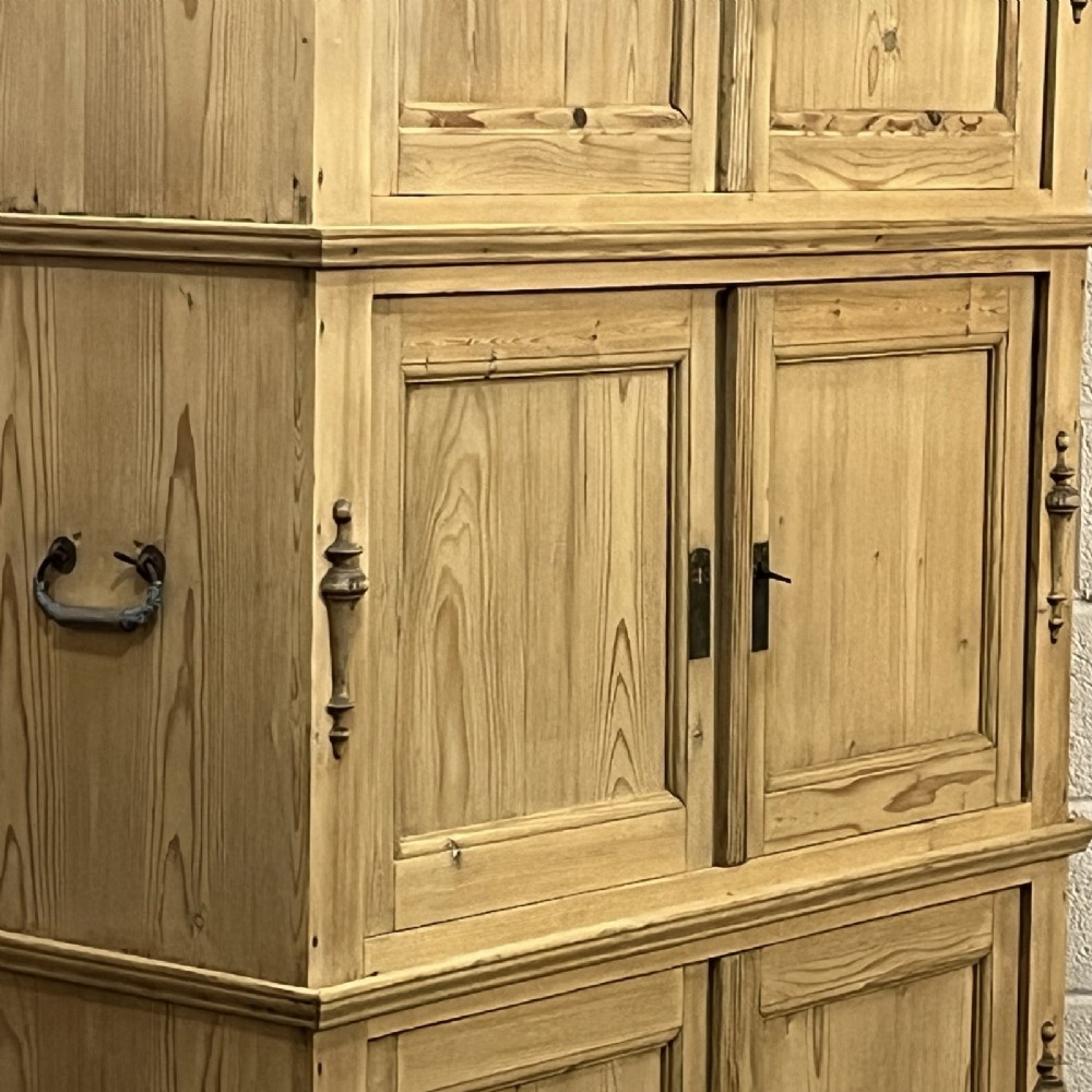 A three-section antique pine campaign cupboard featuring panelled doors, iron carrying handles on the sides, and rounded bun feet. View VIII